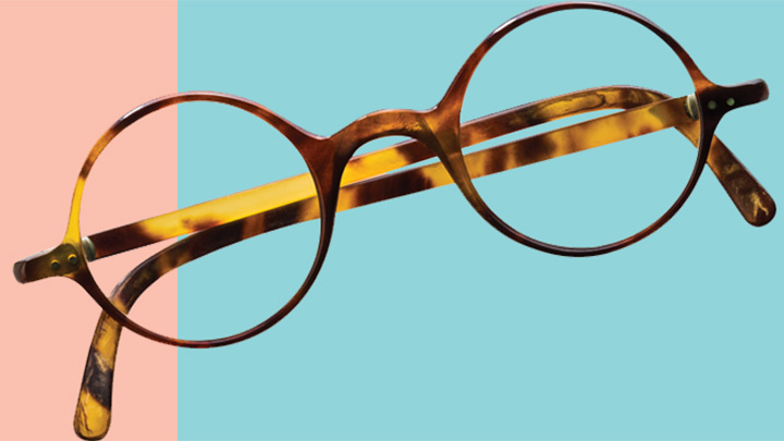 A pair of glasses isolated on a blue and pink background.