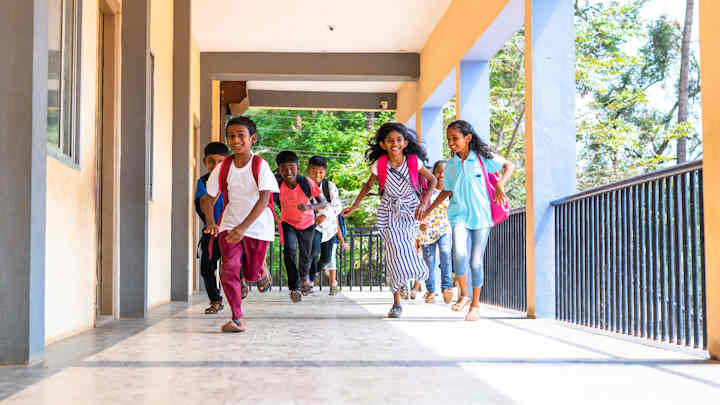 South Asian children running at school.
